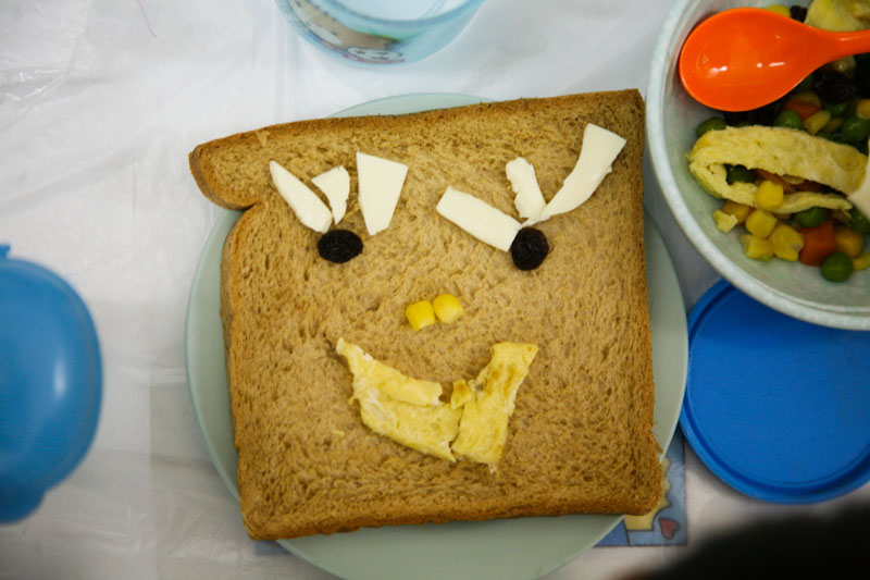 Children use different kinds of food to decorate the bread Children use different kinds of food to decorate the bread