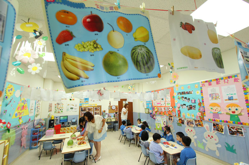 The pictures of fruits and vegetables are being hung in the classroom