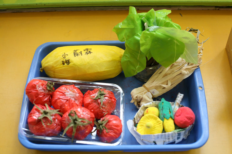 Children use recycled materials to create their own eco-friendly vegetable-shaped accessories with their parents
