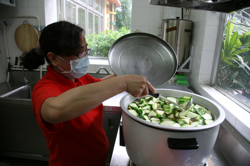 A staff member is cooking vegetables