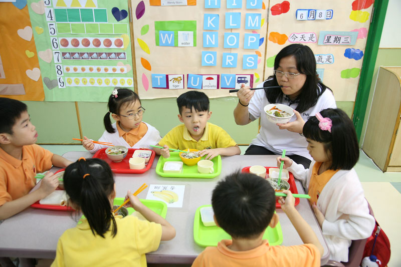 老师与学童一起享用食物