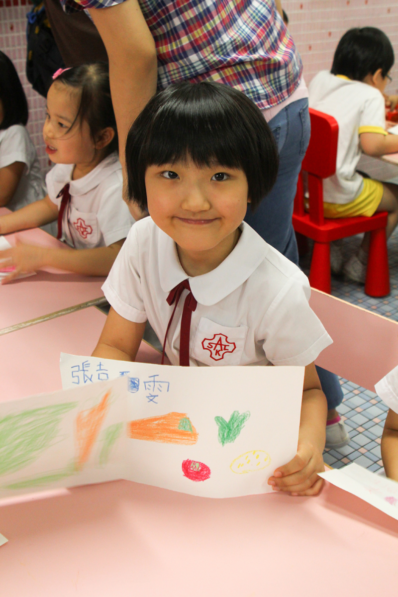 A child is showing her drawing