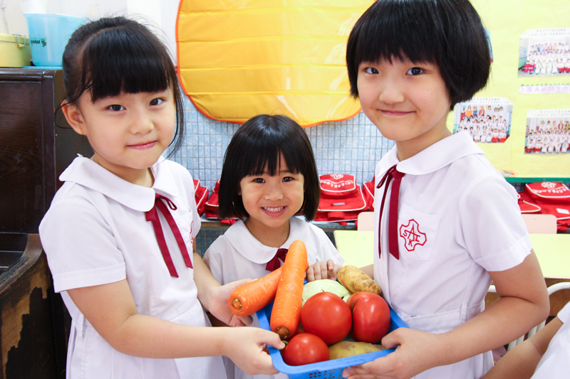 学童手持不同的蔬菜