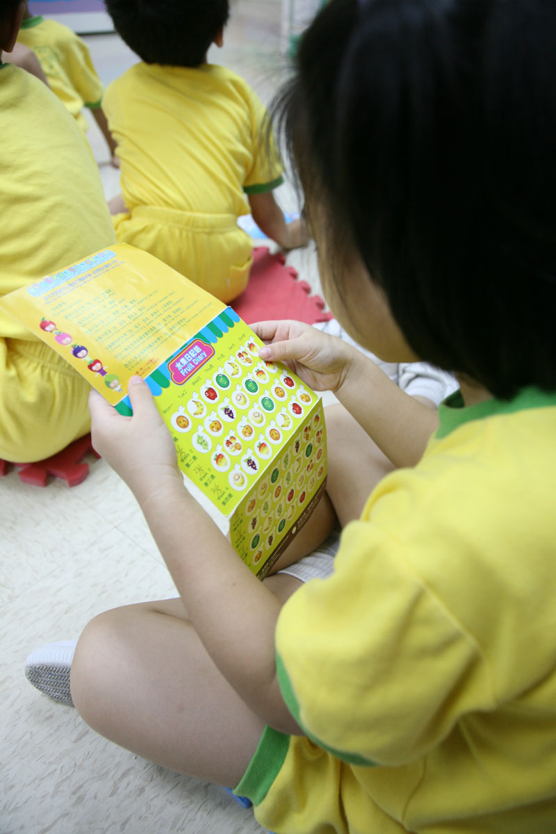 A child is reading the "Fruit Diary Card"