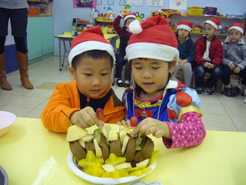 生日的學童與水果清蛋糕合照
