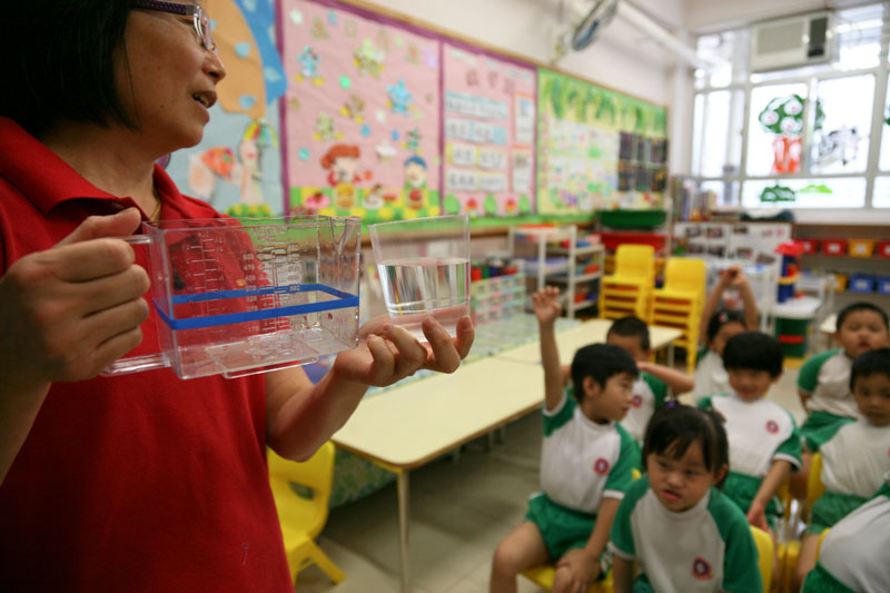 A teacher is asking the children about the volume of a glass of water