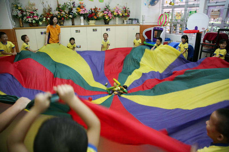 Children are playing rainbow parachute games